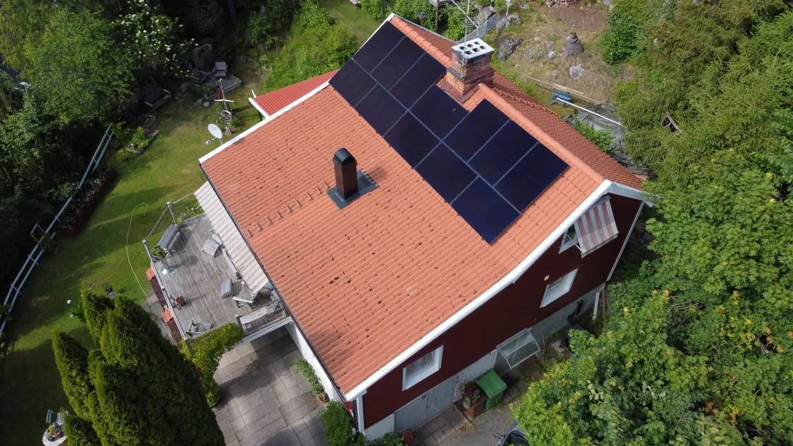 Villa med rött tegeltak där det svarta panelfältet ligger på en del av takfallet, intill skorstenen